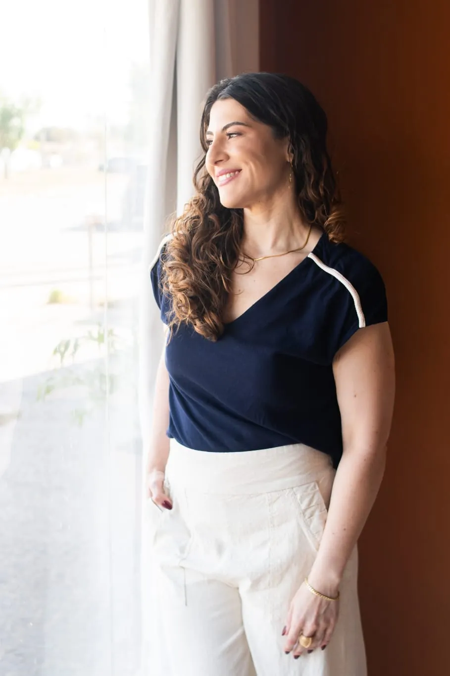 Dra. Milena Amaro Furlan junto à janela, com luz natural